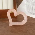 Dettaglio di un fermaglio per capelli a cuore rosa pesca con molla dorata su vassoio - Colore pelle