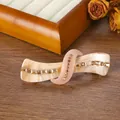 Detail of tortoiseshell acetate spring hair clip with amber rhinestones on wood - Khaki And Korean Pink