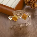 Detail of amber resin hair claw with yellow clovers and rhinestones on wood background - 6.5cm / Champagne Gold