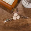 Nahaufnahme der bernsteinfarbenen Haarklammer mit Creme-Blüte, rosa Kristall und Perlen - Koreanisches Rosa 11cm