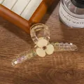 Nahaufnahme einer floralen Haarspange mit bunten Perlen auf einer Holzoberfläche - Champagnergold 11cm