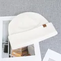 Detail shot of ivory wool knit beanie featuring a brown leather mountain logo patch - One Size(Elastic) / White