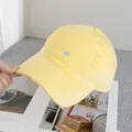 Dettaglio del cappello da baseball in cotone giallo con ricamo blu e bordi usurati - Regolabile / Giallo