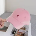 Dettaglio del cappellino da baseball rosa invecchiato con ricamo rosso ed effetto usurato - Regolabile / Rosa