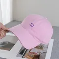 Dettaglio del cappellino da baseball rosa in cotone con ricamo viola e visiera curva - Regolabile / Rosa