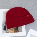 Detailed close-up of dark red wool knit beanie featuring premium rib texture and logo tag - One Size(Elastic) / Red