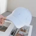 Dettaglio del cappellino da baseball celeste con bordi sfrangiati e ricamo decorativo - Regolabile / Blu