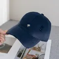 Detailed macro view of navy blue baseball cap with embroidery and distressed ripped details - Adjustable / Navy Blue
