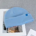 Close-up of light blue 100% wool knit beanie with vertical rib texture and logo tag - Light Blue