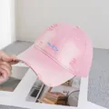 Dettaglio del cappello rosa in cotone con ricamo smile blu ed effetto invecchiato - Regolabile / Rosa
