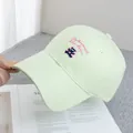 Detailed close-up of light green cotton baseball cap with pink bear and letter embroidery - Adjustable / Green