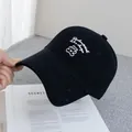 Close-up of black cotton baseball cap with white bear embroidery and artistic text - Adjustable / Black