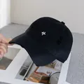Close-up of a distressed black baseball cap with white embroidery and frayed details - Adjustable / Black