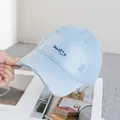 Detail of distressed light blue baseball cap with smile embroidery and ripped texture - Adjustable / Blue
