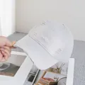 Close-up of Smile embroidery and distressed detail on a grey vintage baseball cap - Adjustable / Light Gray
