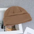 Detail of a brown ribbed wool beanie featuring a mountain logo leather patch on a flat lay - One Size(Elastic) / Camel
