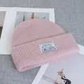 Dettaglio del berretto di lana rosa con trama a costine ed etichetta del marchio - Elasticizzato / Rosa