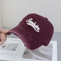 Détail d'une casquette de baseball vintage bordeaux avec broderie et bord usé - Réglable / Bordeaux