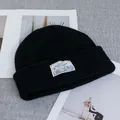 Close-up of black wool knit beanie featuring a white logo patch with Winter Wonderland text - Stretchy / Black