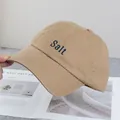 Dettaglio del cappellino kaki con ricamo Salt blu e cuciture sulla visiera curva - Regolabile / Cachi