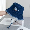 Detail view of denim bucket hat with gray cat embroidery and rustic frayed edges - Adjustable / Dark Blue