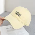 Detalle de la gorra crema con bordado Pride and Prejudice en azul marino - Ajustable / Amarillo