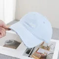 Detailed close-up of light blue cotton baseball cap with okey embroidery and distressed edges - Adjustable / Blue