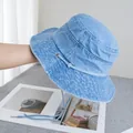 Dettaglio del cappello a secchiello in denim celeste con occhielli in metallo e coulisse - Regolabile / Azzurro