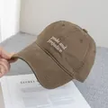 Detailed close-up of dark brown baseball cap with white Pride and Prejudice embroidery - Adjustable / Camel