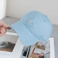 Detalle del bordado 'Oi look at me' en gorra de béisbol de algodón azul claro en la mano - Ajustable / Azul
