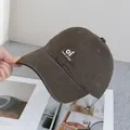 Detailed view of embroidery text and stitch quality on the brown cotton baseball cap - Adjustable / Coffee