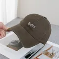 Detail van de katoenen honkbalpet met wit cursief Backing borduursel op bruin canvas - Verstelbaar / koffiekleur