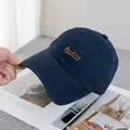 Detail of navy blue canvas baseball cap with orange Backing embroidery and reinforced stitching - Adjustable / Navy Blue