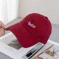 Close-up of white Baching letter embroidery on a burgundy cotton baseball cap - Adjustable / Burgundy