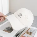 Dettaglio del gatto ricamato e dei fori usurati sul cappello in tela bianco avorio - Regolabile / Bianco Sporco