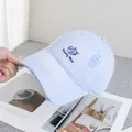 Detailed close-up of blue distressed denim cap with cat embroidery and frayed holes - Adjustable / Purple