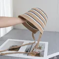 Macro detail of khaki straw bucket hat featuring blue and white stripes and woven ties - M / Khaki