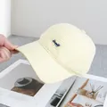 Close-up of yellow gingham baseball cap featuring blue Happy embroidered lettering - Adjustable / Yellow