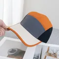 Detail einer 5-Panel-Camper-Mütze mit orangefarbenem Rand und verstärktem Schirm - Verstellbar / Grau Mit Beigem Schirm