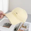 Detalle de la gorra de béisbol amarillo claro con bordado 'Art' y textura de algodón suave - Ajustable / Amarillo
