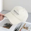 Detail of beige cotton baseball cap with embroidered grey DISREOVRY text and curved brim - Adjustable / Beige