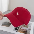 Detaillierte Nahaufnahme einer dunkelroten Baseballkappe mit weißem Hunde-Stickmotiv - Burgunderrot