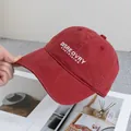 Detailed close-up of brick red washed cotton baseball cap with white letter embroidery - Adjustable / Burgundy