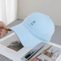 Detailopname van HoHoHo-borduurwerk op lichtblauwe katoenen pet boven een magazine - Verstelbaar / Blauw