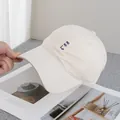 Detail van HoHoHo-borduurwerk op een minimalistische beige katoenen baseballpet met stevige klep - Verstelbaar / Beige