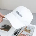 Detail of white cotton baseball cap with dark letter embroidery and curved brim design - Adjustable / White
