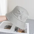 Gros plan détaillé sur les finitions déchirées d'un chapeau bob en toile gris clair - Réglable / Gris clair