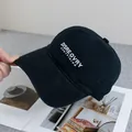 Close-up of white letter embroidery on a washed black cotton baseball cap - Adjustable / Black