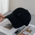 Detailopname van de zwarte katoenen baseballpet met paars HO HO HO geborduurd logo - Verstelbaar / Zwart