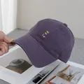 Detailopname van het gele HO HO ho-borduurwerk op een ademende paarse baseballpet - Verstelbaar / Paars